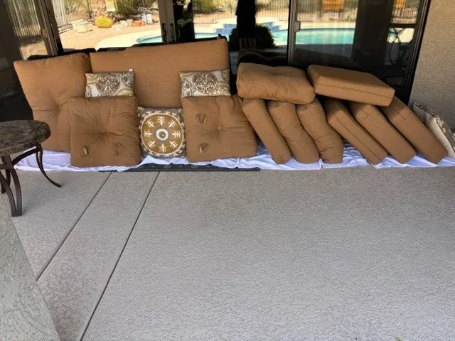 Patio cushions laid out beside a pool ready for cleaning